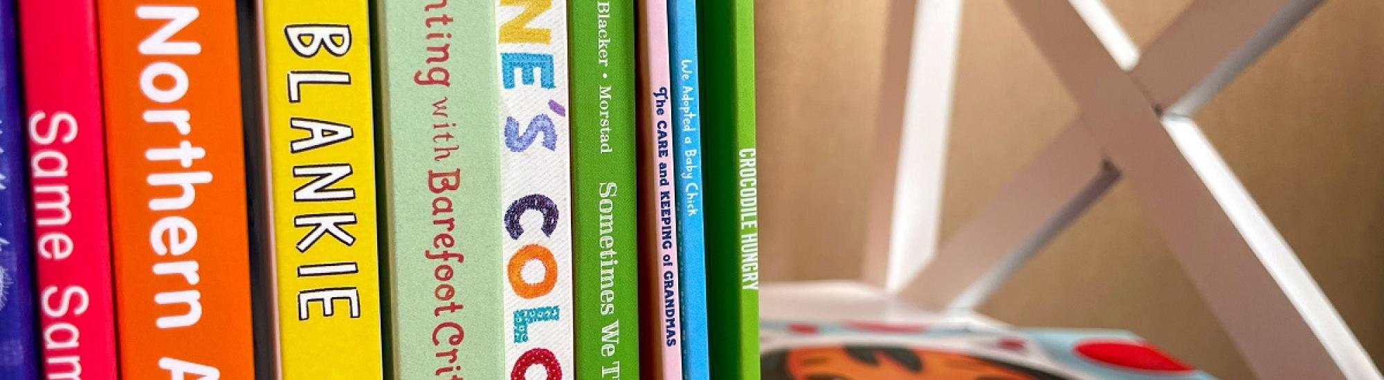 Colorful Kids books stacked vertically on a book shelf with titles like Anne's Colors and Blankie